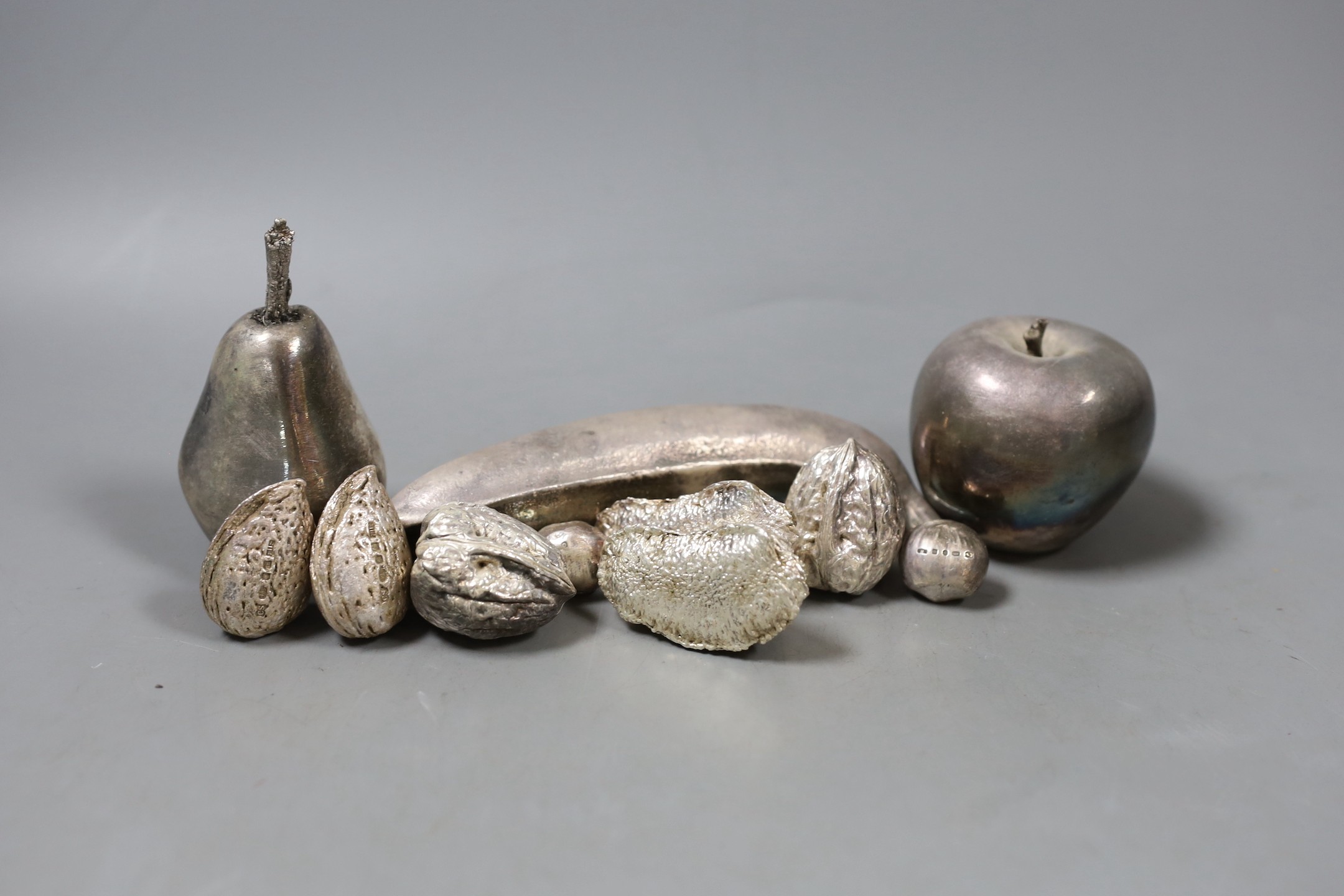 A group of novelty modern filled silver nuts, including Brazil, cob and walnut and three unmarked white metal fruits, banana 15.1cm.